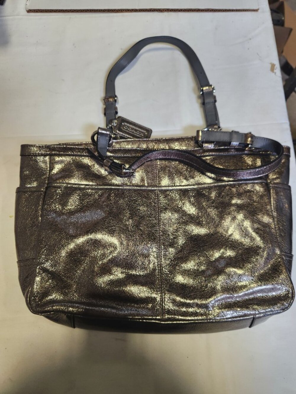 This metallic pewter Coach Gallery Signature East West shoulder handbag features